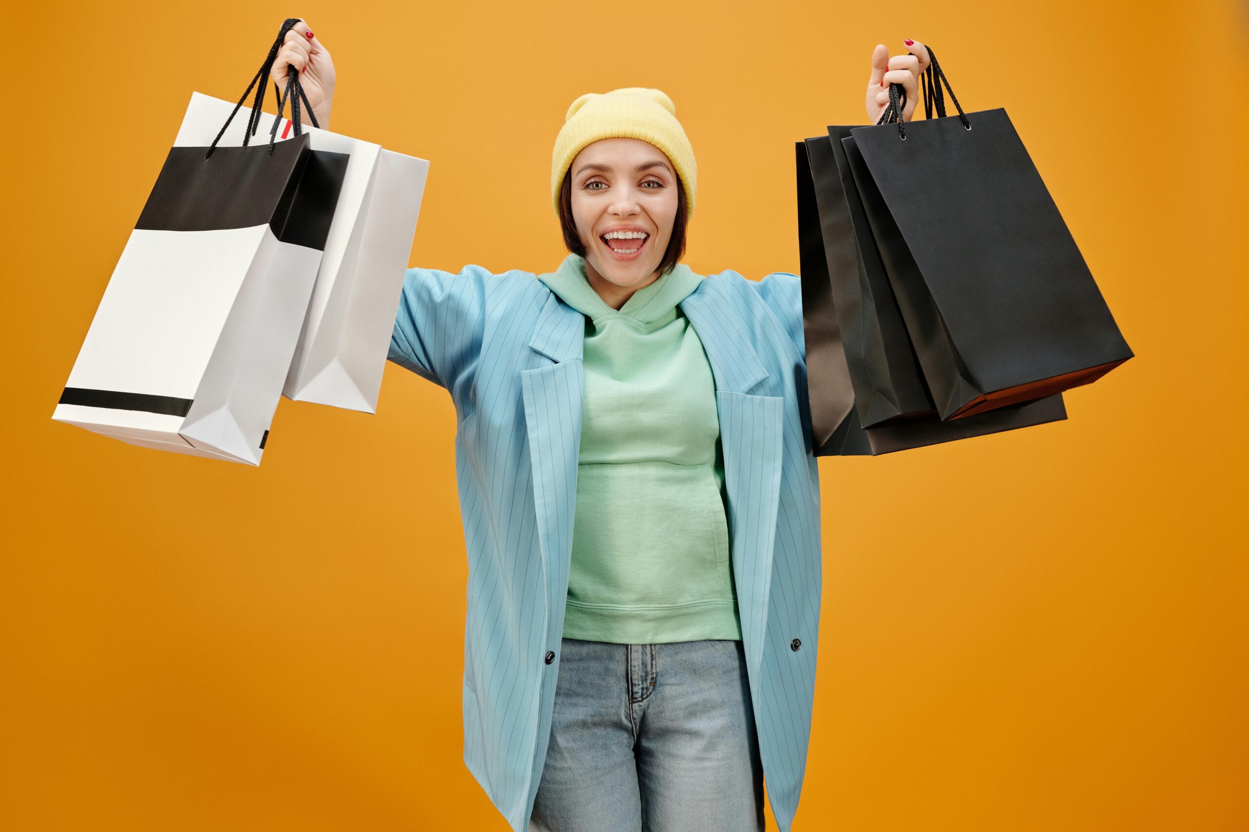 Happy traveler holding up newly purchased clothing after receiving insurance payout
