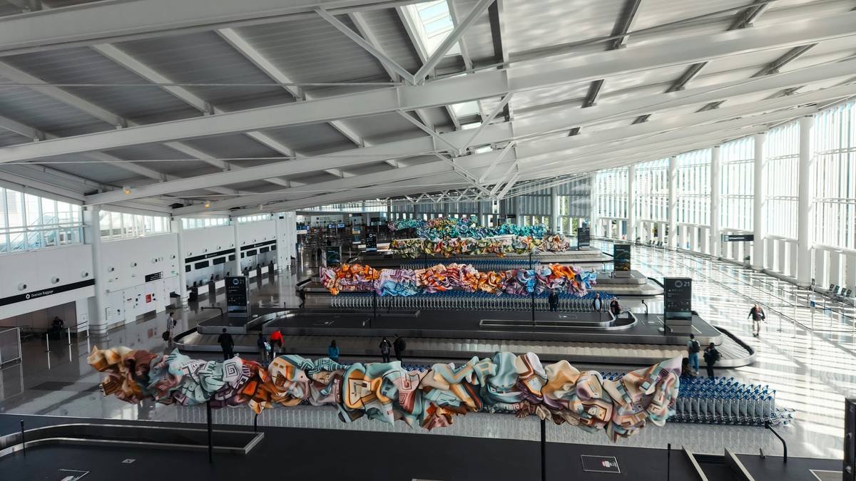 A relieved traveler holding a recovered suitcase with a GPS tracker visible inside.