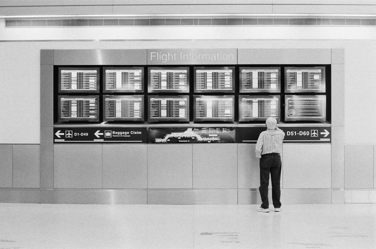 Illustration of a traveler looking frustrated as their delayed luggage sits on a conveyor belt.
